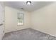 Neutral bedroom featuring a window for natural light, carpeted floors, and a door at 197 Devon Forest Dr, Mooresville, NC 28115
