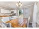 Bright dining area adjacent to the kitchen featuring a wooden table, white chairs, and modern lighting at 197 Devon Forest Dr, Mooresville, NC 28115