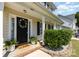 Close-up view of front door, with a wreath, black door and potted plants at 197 Devon Forest Dr, Mooresville, NC 28115