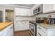 Close-up of kitchen featuring stainless steel appliances, white cabinets, and granite countertops at 197 Devon Forest Dr, Mooresville, NC 28115