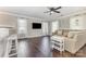 Bright living room featuring dark hardwood floors, ceiling fan, and large windows at 197 Devon Forest Dr, Mooresville, NC 28115