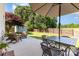 Cozy patio with an umbrella covered dining table and comfortable Adirondack chairs surrounding a fire pit at 197 Devon Forest Dr, Mooresville, NC 28115