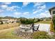 Landscaped backyard featuring a stone fire pit, patio area, and picturesque neighborhood views at 2014 Drawbridge Dr, Fort Mill, SC 29707