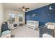 Cozy Bedroom with blue accent wall, white crib, rocking chair, and ample natural light at 2014 Drawbridge Dr, Fort Mill, SC 29707