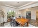Dining room showing a wood table with chairs, tray ceiling, and large window letting in natural light at 2014 Drawbridge Dr, Fort Mill, SC 29707