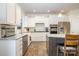 Bright kitchen boasting granite countertops, stainless steel appliances, white cabinets and a breakfast bar at 2014 Drawbridge Dr, Fort Mill, SC 29707