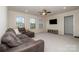 Relaxing living room featuring soft carpet, large windows, ceiling fan and entertainment center at 2014 Drawbridge Dr, Fort Mill, SC 29707