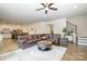 Open-concept living room with a large sectional sofa, hardwood floors, and an adjacent kitchen and dining area at 2014 Drawbridge Dr, Fort Mill, SC 29707