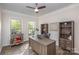 Bright office space with hardwood floors, two windows for natural light, a ceiling fan, and bookshelves at 2014 Drawbridge Dr, Fort Mill, SC 29707