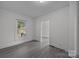 Neutral-toned bedroom featuring natural light from the window and an open doorway at 207 Eden St, Davidson, NC 28036