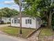 Charming home featuring a well-kept lawn and brick accents, complemented by mature trees at 207 Eden St, Davidson, NC 28036