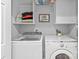 Bright laundry room with modern washer and dryer units and built-in shelving at 20840 Sierra Vista Dr, Cornelius, NC 28031