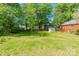 Expansive backyard featuring lush green grass, mature trees, and a storage shed, great for outdoor activities at 211 E Mcneely Ave, Mooresville, NC 28115