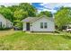 Charming single-story home with white siding, a well-manicured lawn, and lush green trees at 211 E Mcneely Ave, Mooresville, NC 28115