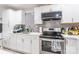 Well-appointed kitchen features stainless steel appliances, sleek white cabinets, and a stylish backsplash at 211 E Mcneely Ave, Mooresville, NC 28115