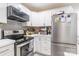 Stylish kitchen features stainless steel appliances, modern white cabinets, and gray backsplash at 211 E Mcneely Ave, Mooresville, NC 28115