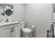 Efficient laundry area with modern white appliances, cabinets, and a round mirror for added functionality at 211 E Mcneely Ave, Mooresville, NC 28115