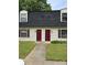 Charming townhome with red doors, matching shutters and dormer windows surrounded by a well-maintained lawn at 2224 Yorkhills Dr # 7, Charlotte, NC 28217