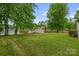This home features a large, lush green lawn leading to the serene lake at 235 Pebble Point Rd, Salisbury, NC 28146