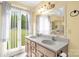 Bathroom features a double sink vanity, ornate mirror, and a window view of the yard at 235 Pebble Point Rd, Salisbury, NC 28146