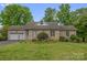 Charming brick home features a well-manicured lawn, mature trees, and a two-car garage at 235 Pebble Point Rd, Salisbury, NC 28146