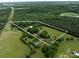 Expansive aerial view of the property showcasing the house, barn, and surrounding lush greenery at 2500 Cedar Cove Dr, Harrisburg, NC 28075