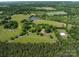 Aerial view highlighting the estate with its home, pond, outbuildings, and surrounding green pastures at 2500 Cedar Cove Dr, Harrisburg, NC 28075
