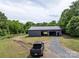 Spacious metal barn with gravel driveway, showcasing a functional and well-maintained outbuilding at 2500 Cedar Cove Dr, Harrisburg, NC 28075