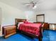Bedroom featuring dark wood furniture, ceiling fan, and blue carpet at 2500 Cedar Cove Dr, Harrisburg, NC 28075