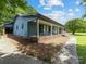 Angled view of the house showing a long front porch with stone floor and rocking chairs at 2500 Cedar Cove Dr, Harrisburg, NC 28075