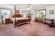 A large bedroom with a four-poster bed, matching nightstands, and a vanity with a round mirror at 2500 Cedar Cove Dr, Harrisburg, NC 28075