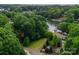 Stunning aerial view of a lakeside property surrounded by lush trees with a glimpse of a private dock at 328 Whippoorwill Rd, Mooresville, NC 28117