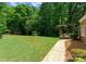 Backyard with a lush green lawn, mature trees, and a charming patio area, ideal for outdoor enjoyment at 328 Whippoorwill Rd, Mooresville, NC 28117