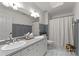 Bathroom featuring double vanity sinks and a large mirror, with neutral colors and a tile floor at 328 Whippoorwill Rd, Mooresville, NC 28117