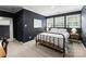 Bedroom with dark walls, three windows with white trim, and a metal-frame bed with neutral-colored linens at 328 Whippoorwill Rd, Mooresville, NC 28117