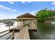 Covered dock with a serene waterfront view, offering a peaceful spot for boating and enjoying lakeside living at 328 Whippoorwill Rd, Mooresville, NC 28117
