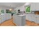 Open kitchen with white cabinets, center island, stainless steel appliances, and hardwood floors at 328 Whippoorwill Rd, Mooresville, NC 28117