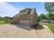 Rear view of brick home with a three car garage and a paved driveway at 335 Wintergreen Ct, Kings Mountain, NC 28086