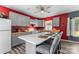 Bright eat-in kitchen with gray cabinets, red accent wall, wood countertops, and island seating at 35 Telephone Exchange Rd, Hickory, NC 28601