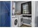 Laundry room with side-by-side machines, black & white curtains, a blue door and overhead lighting at 35 Telephone Exchange Rd, Hickory, NC 28601