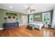 Bedroom featuring green walls, hardwood floors, two windows, and a comfortable double bed at 3707 Seagrave Farm Rd, Concord, NC 28025