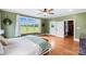 Green-walled bedroom filled with sunlight showcasing hardwood floors, a double bed, and exterior access at 3707 Seagrave Farm Rd, Concord, NC 28025
