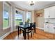 Bright dining room with views of nature, featuring a black table and hardwood floors at 3707 Seagrave Farm Rd, Concord, NC 28025