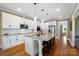 Modern kitchen with white cabinets, an island with seating, and stainless steel appliances at 3707 Seagrave Farm Rd, Concord, NC 28025