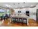 Bright, modern kitchen with white cabinets, marble countertops, large island and wood floors at 3707 Seagrave Farm Rd, Concord, NC 28025