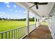 Covered porch with ceiling fans offering beautiful view of the green fields in the backyard at 3707 Seagrave Farm Rd, Concord, NC 28025