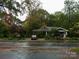 Well-maintained bungalow with a welcoming front porch, surrounded by lush trees and a serene neighborhood ambiance at 4311 Commonwealth Ave, Charlotte, NC 28205
