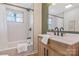 Well-lit bathroom features a shower/tub combo with neutral tiling, modern vanity, and matte black fixtures at 4566 Fork Rd, Norwood, NC 28128