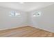 Neutral bedroom featuring hardwood floors and two windows, creating a bright and airy space at 4566 Fork Rd, Norwood, NC 28128