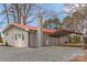Side view of gray brick home with red roof, driveway, and carport at 4566 Fork Rd, Norwood, NC 28128